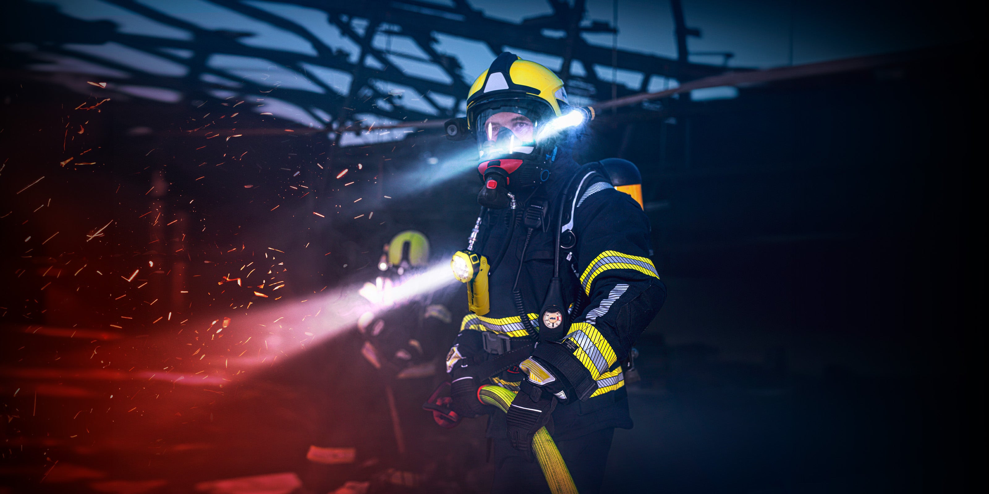 Adalit USA Firefighter in action with a flashlight in a dark, smoky environment